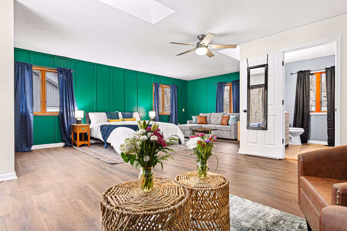 Master suite with green accent wall and king bed