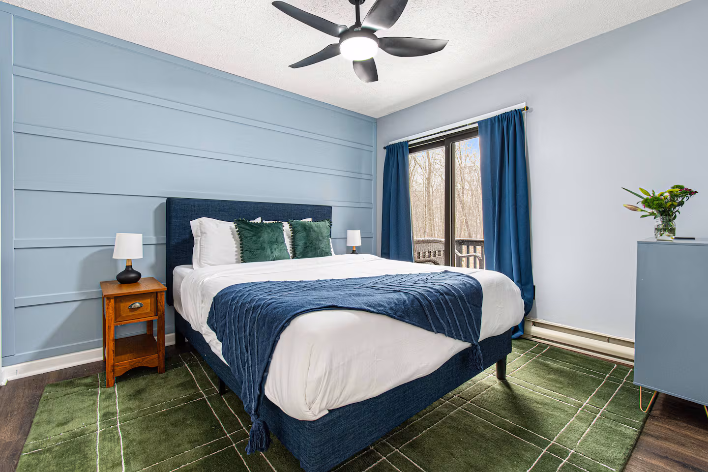 Blue shiplap bedroom with sliding door to deck